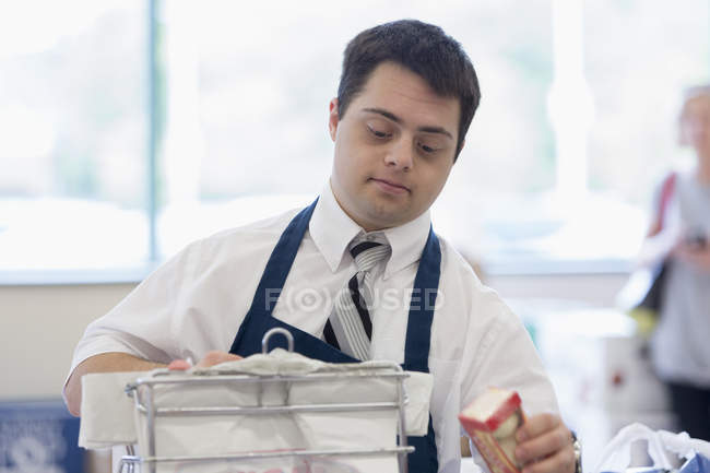 Homme avec trisomie 21 travaillant dans une épicerie — Photo de stock