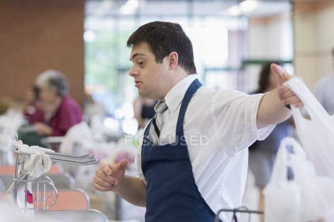 Mann mit Down-Syndrom arbeitet in einem Lebensmittelgeschäft — Stockfoto