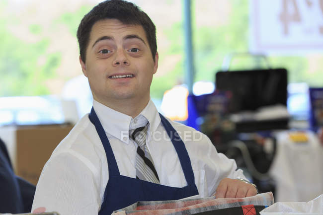 Homem com Síndrome de Down trabalhando em uma mercearia — Fotografia de Stock