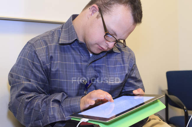 Portrait of hospital aid worker with Down Syndrome working in office — Stock Photo