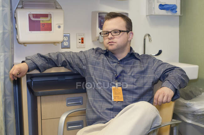 Portrait d'un travailleur humanitaire hospitalisé atteint de trisomie 21 travaillant au bureau — Photo de stock