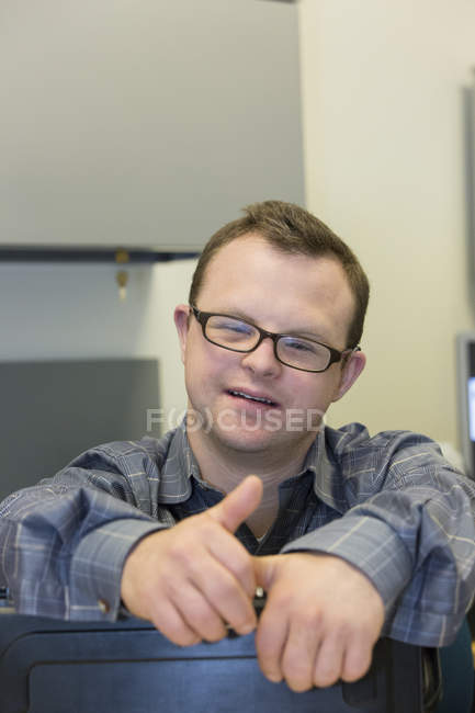 Retrato de assistente hospitalar com síndrome de Down trabalhando no escritório — Fotografia de Stock