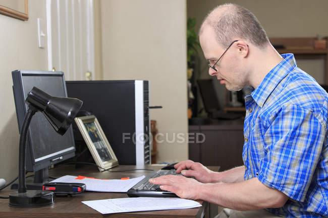 Retrato del trabajador de ayuda hospitalaria con síndrome de Down que trabaja en la oficina - foto de stock