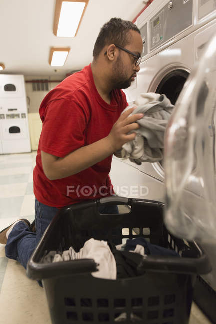 Afrikanisch-amerikanischer Mann mit Down-Syndrom für Waschküche im Hauswirtschaftsraum — Stockfoto