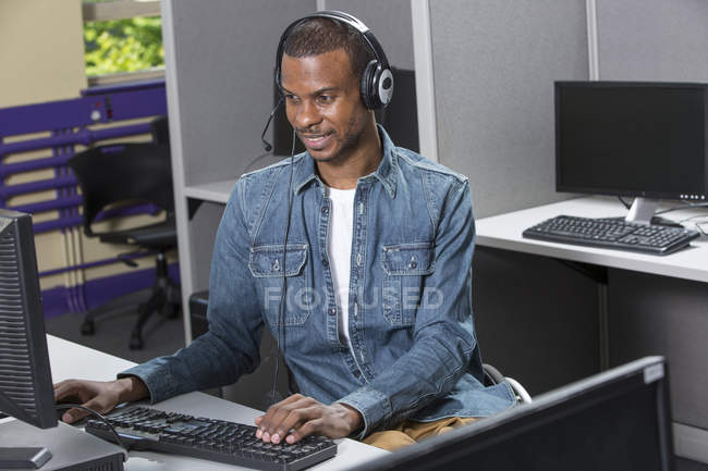 Man who had Spinal Meningitis in a wheelchair working in a call center — Stock Photo