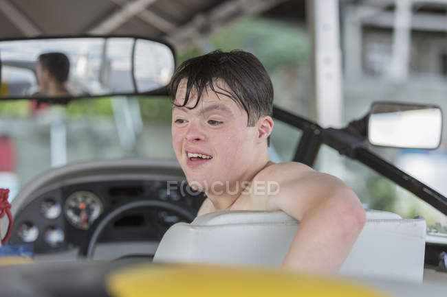 Молодий чоловік з синдромом Дауна їде в човні. — стокове фото