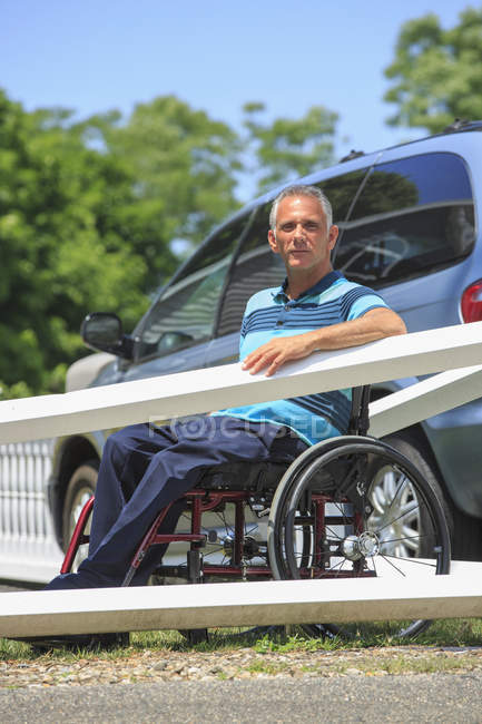 Homem com uma lesão medular na cadeira de rodas na frente de seu carro acessível — Fotografia de Stock