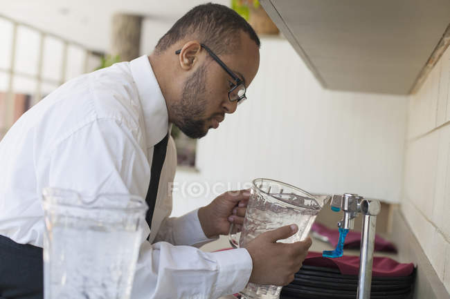 African American man with Down Syndrome as a waiter working in restaurant — Stock Photo
