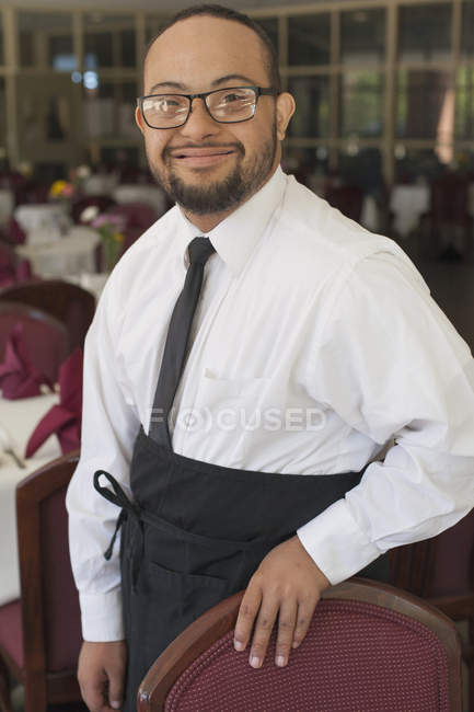 Афроамериканець людина з синдромом Дауна як офіціант працює в ресторані — стокове фото