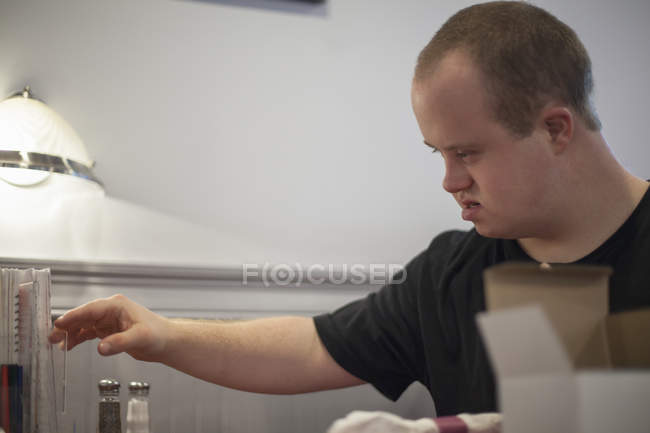 Кавказский человек с синдромом Дауна работает в ресторане — стоковое фото