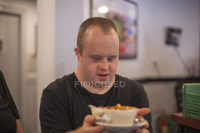 Caucásico hombre con síndrome de Down trabajando en restaurante - foto de stock