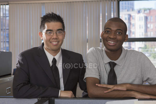 Hombre afroamericano y asiático con autismo trabajando en la oficina - foto de stock