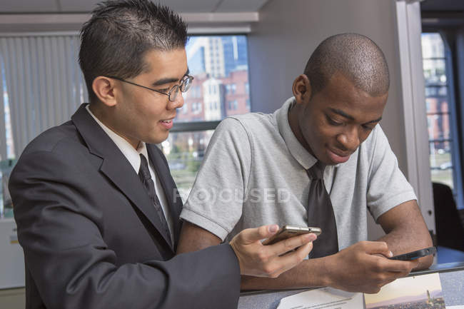 African American man and Asian with Autism working in office — Stock Photo