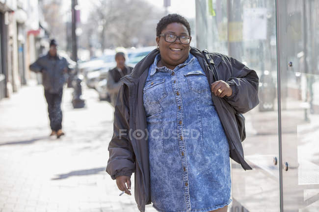 Glückliche Frau mit bipolarer Störung, die in ihrer Nachbarschaft läuft und raucht — Stockfoto