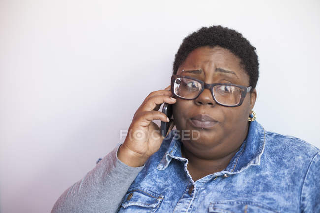 Primer plano de una mujer con trastorno bipolar hablando por teléfono celular - foto de stock