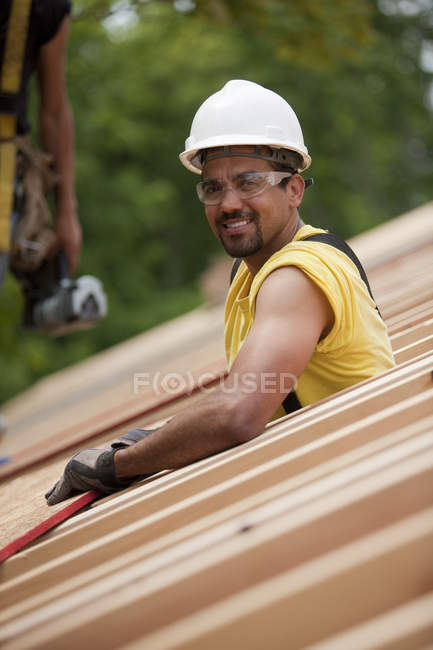 Hispanic carpenters placing roof panel at a house under construction — Stock Photo