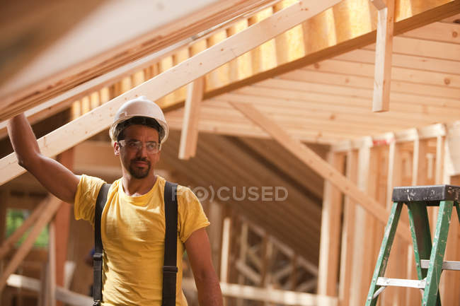 Hispanic carpenter working at a house under construction — Stock Photo