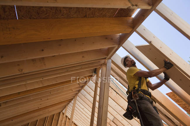 Charpentier hispanique travaillant dans une maison en construction — Photo de stock