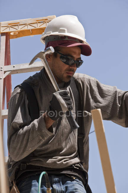 Carpenter hammering wood at a construction site — Stock Photo