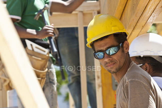Charpentiers préparant une poutre laminée sur un chantier de construction — Photo de stock