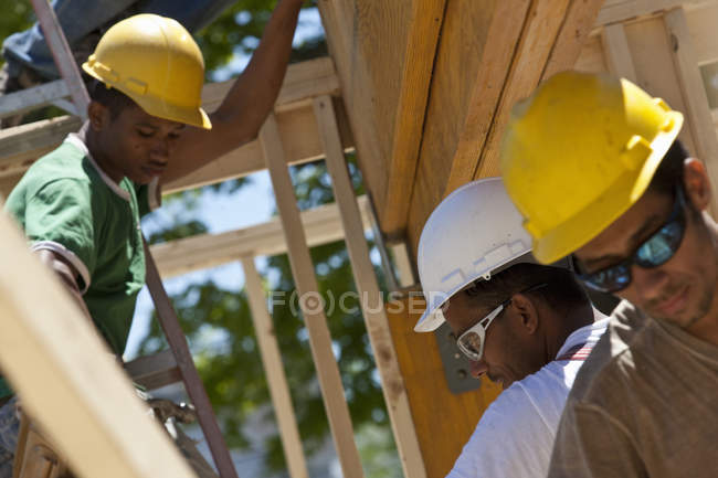 Плотники готовят ламинированный луч на строительной площадке здания — стоковое фото