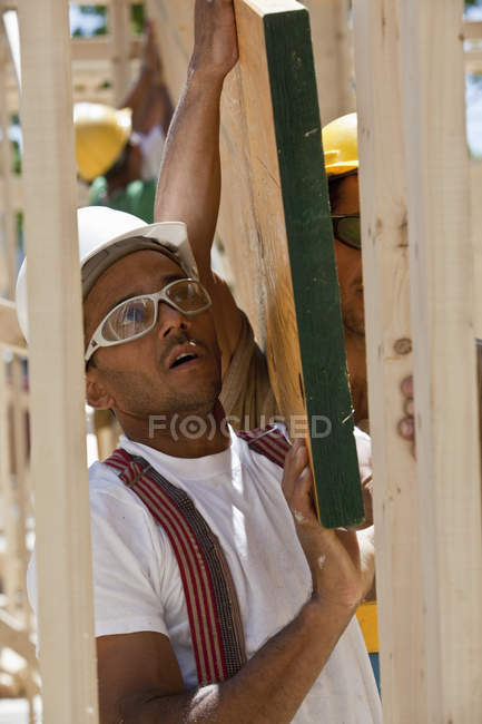 Zimmerleute heben Balken auf einer Baustelle — Stockfoto