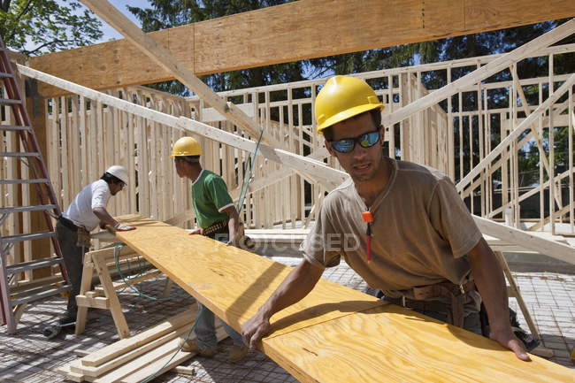 Zimmerleute heben auf einer Baustelle einen Brettschichtholz an — Stockfoto