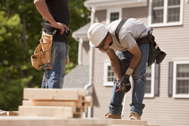 Trabalhos de carpintaria marcando pregos em um canteiro de obras — Fotografia de Stock