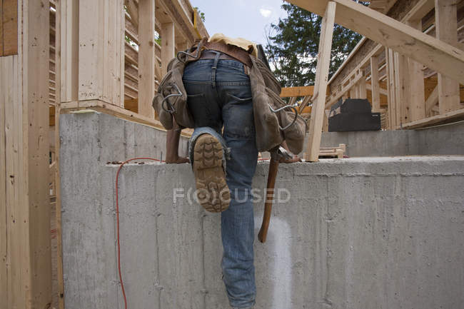 Плотник осматривает фундамент на строительной площадке — стоковое фото