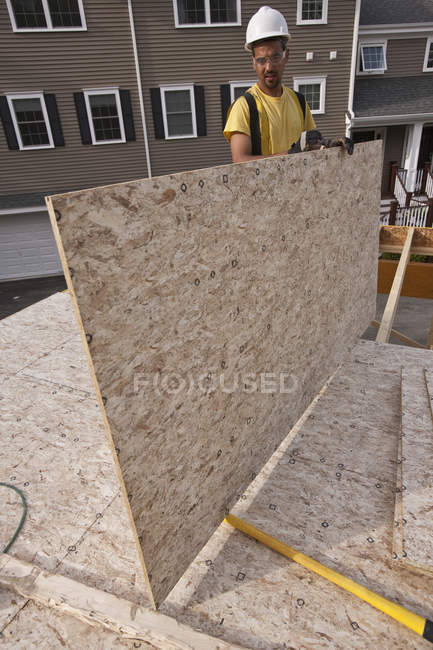 Tischler bewegt Spanplatten auf einer Baustelle — Stockfoto