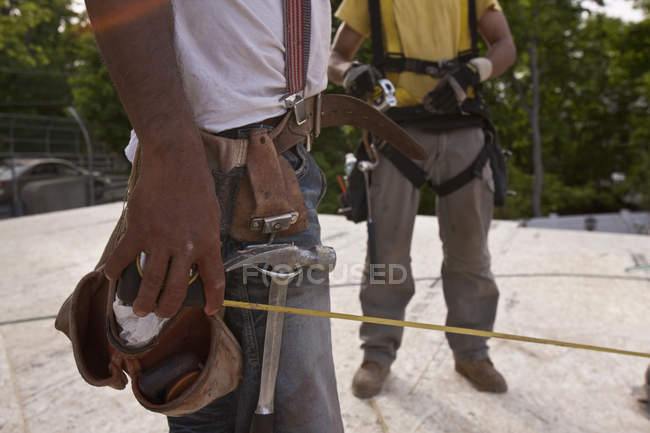 Charpentiers avec ruban à mesurer et outils sur un chantier de construction — Photo de stock