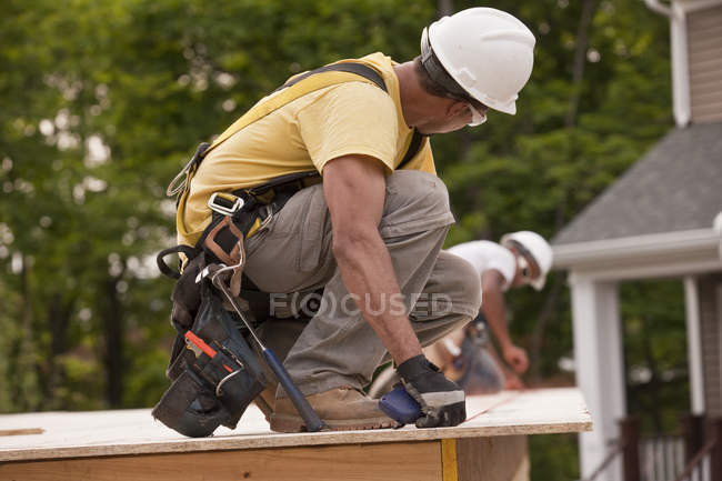 Carpenters laying a snap line on a particle board using chalk line — Stock Photo