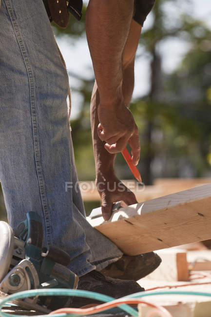 Misure di marcatura falegname su legno in un cantiere edile — Foto stock