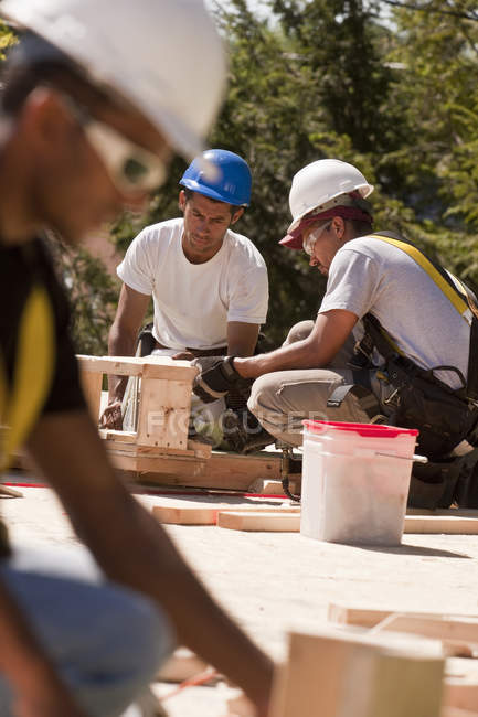 Trabalhos de carpintaria que trabalham com materiais de enquadramento num estaleiro de construção — Fotografia de Stock