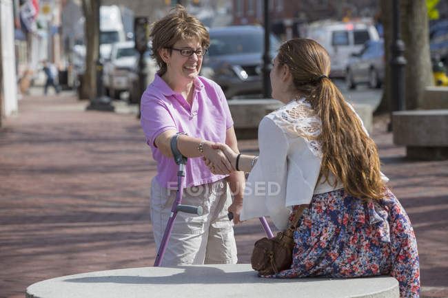 Frau mit Zerebralparese grüßt ihre Schwester auf der Straße — Stockfoto