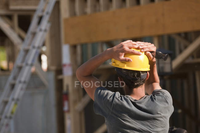 Trabalhador da construção civil que contempla no estaleiro — Fotografia de Stock