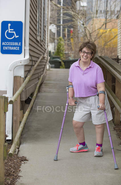 Woman with Cerebral Palsy walking down an accessible ramp — Stock Photo