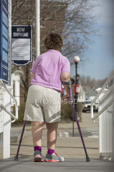 Frau mit Zerebralparese läuft eine barrierefreie Rampe hinunter — Stockfoto