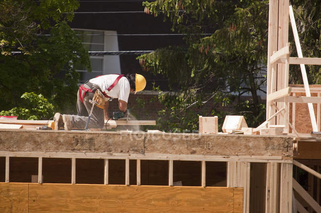 Carpenter Sawing with circular saw on second floor — Stock Photo
