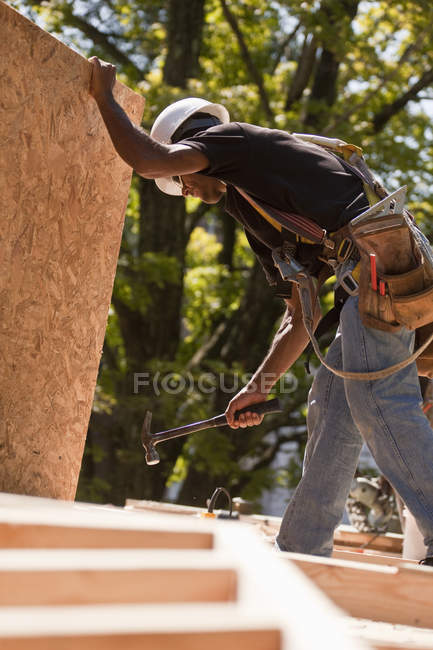 Falegname martellare un pannello di particelle in una costruzione — Foto stock