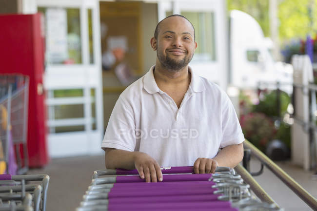 Homem com Síndrome de Down escolher um carrinho de supermercado — Fotografia de Stock
