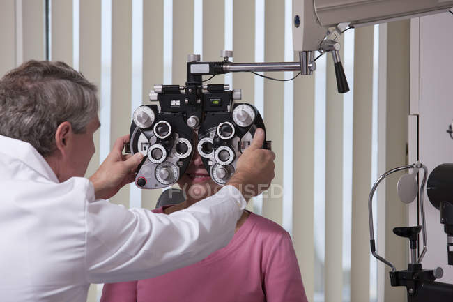 Ophtalmologiste plaçant le phoropter devant une patiente — Photo de stock