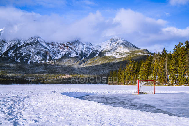 Lago Piramide ghiacciato con rete da hockey su una pista di pattinaggio sul ghiaccio in inverno, Jasper National Park; Alberta, Canada — Foto stock