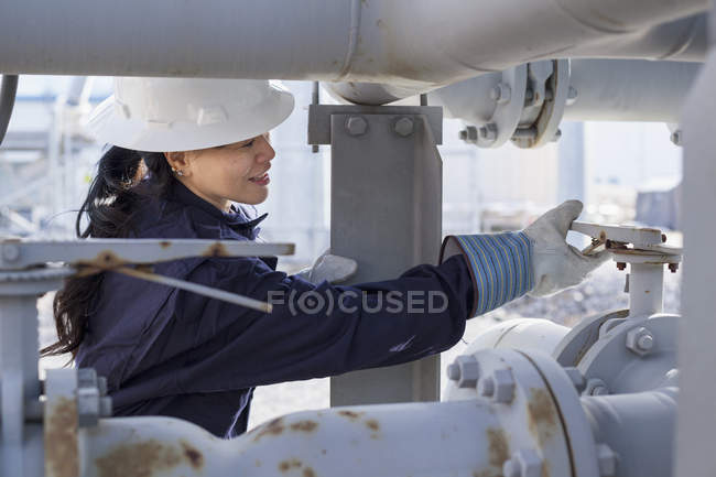 Жінка-енергетик регулює клапан тиску на електростанції — стокове фото