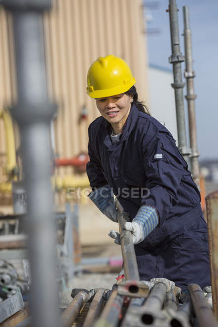 Female power engineer sorting through scaffolding at power plant — Stock Photo