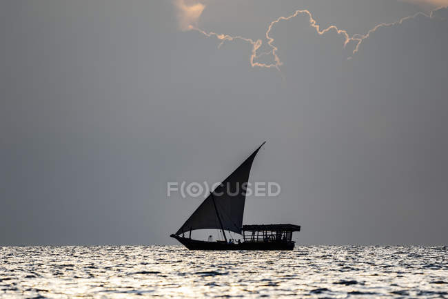 Dhow on the Indian Ocean at sunset; Zanzibar City, Unguja Island, Zanzibar, Tanzania — стокове фото
