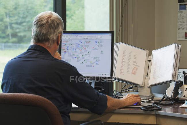 Un ingénieur sur ordinateur démarre l'usine de traitement des eaux au programme pour superviser le contrôle et l'acquisition des données — Photo de stock