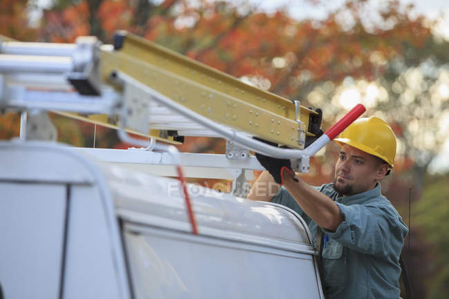 Lineman colocando escada de volta no caminhão no local — Fotografia de Stock