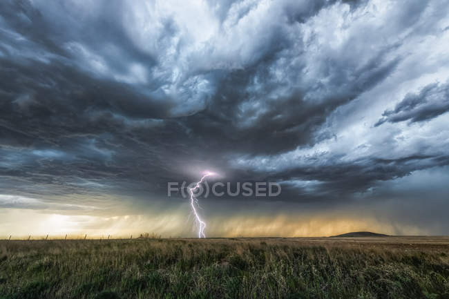 Chuvas à distância nas pradarias sob nuvens de tempestade ameaçadoras; Saskatchewan, Canadá — Fotografia de Stock