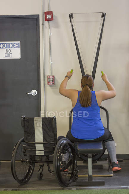 Woman with spinal cord injury working out in a gym — Stock Photo